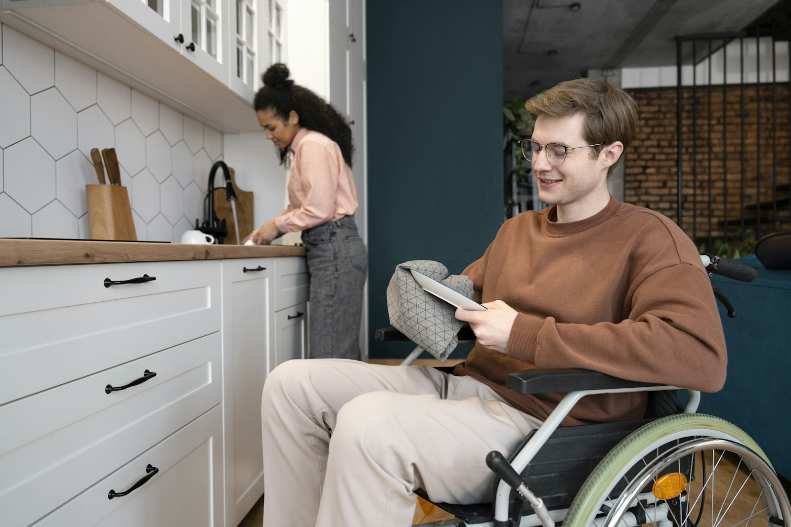 A man in a wheelchair using a tablet at home